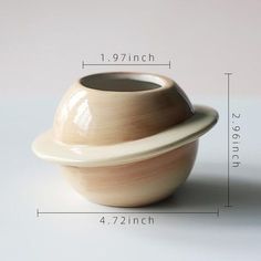 an image of a white vase with saturn on the bottom and side, measurements for it