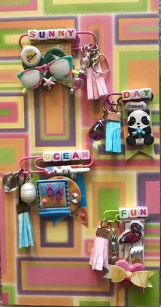 several key chains hanging on a wall with pictures and charms attached to them in front of a multi - colored background