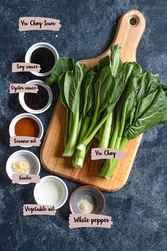 some green vegetables are on a cutting board with sauces and seasonings around them