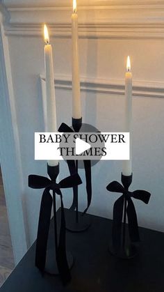 three candles are sitting on a table with the words baby's shower in front of them