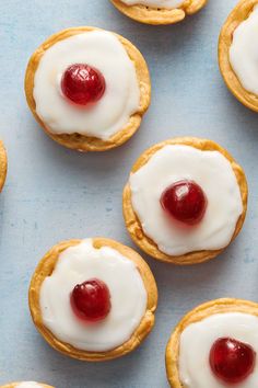 small pastries with cream and cherries on them