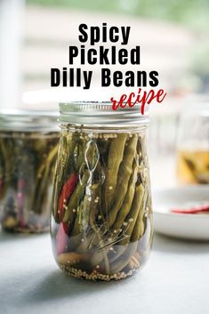 three jars filled with pickled dill beans on top of a table