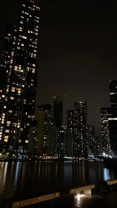 the city is lit up at night by the water