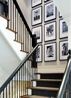 a staircase with pictures on the wall and carpeted stairs leading up to the second floor