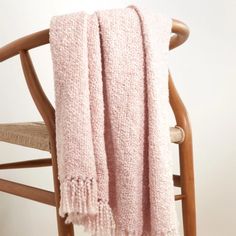 a pink blanket sitting on top of a wooden chair