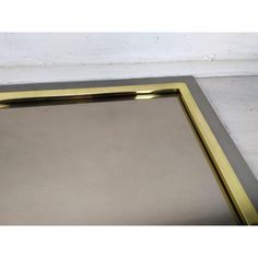 a gold framed mirror sitting on top of a white wall