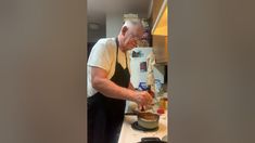 an old man is cooking in the kitchen