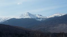 the mountains are covered in snow and trees