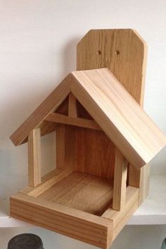 a wooden bird house sitting on top of a shelf