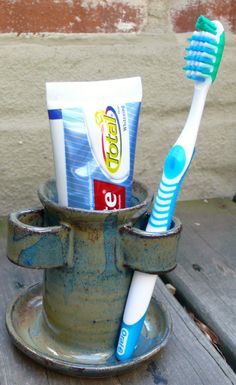 two toothbrushes in a cup on a table