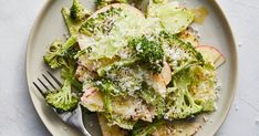 a white plate topped with pasta and broccoli covered in parmesan cheese