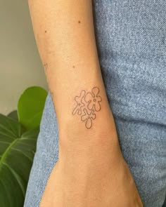 a woman's arm with a small flower tattoo on the left side of her wrist