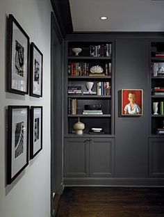 a hallway with bookshelves and pictures on the wall