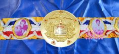 a gold belt with two pictures on it and an award ribbon around the waistline