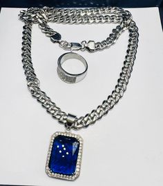 Add a touch of elegance to your outfit with this beautiful necklace. The necklace features a Cuban link chain made of durable stainless steel, with a wide 0.5 inch width. The blue charm adds a pop of color to the silver-colored necklace, making it perfect for any occasion, whether it's a Christmas celebration, anniversary, or birthday. The necklace is 18 inches long and has a pavé setting style, with no stone. The pendant/locket type is a charm, and the style is chain, pendant, charm, and chain charm. The necklace is perfect for those who love the hip hop theme and want to add a touch of style to their outfit. Pendant Locket, Blue Charm, Blue Pendant, Necklace Making, Christmas Celebration, Pave Setting, Cuban Link Chain, Colourful Necklace, Cuban Link