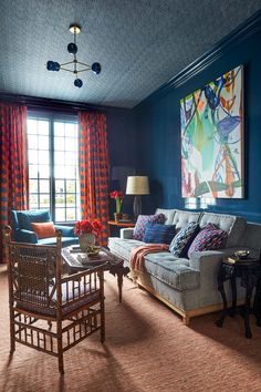 a living room with blue walls and red curtains