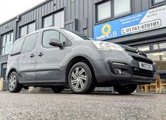 a grey van parked in front of a building