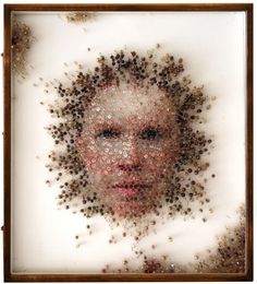 a woman's face is covered in tiny brown and red objects, including hair