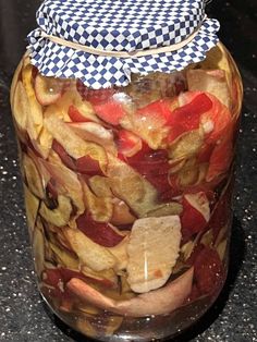 a jar filled with sliced fruit sitting on top of a counter