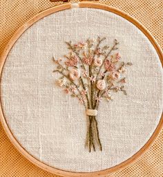 a close up of a embroidery on a piece of cloth with flowers in the middle