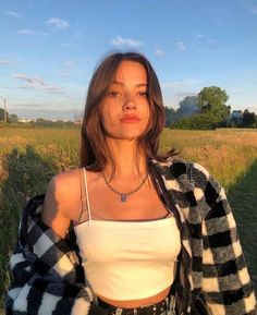 a woman standing in the middle of a field