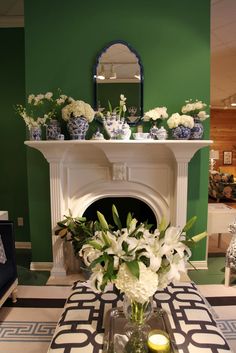 a vase with white flowers sitting on top of a table next to a fire place