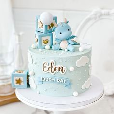 a blue cake with an elephant on top and stars around the edges, sitting on a table