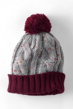 a knitted hat with a red pom - pom on the top and bottom