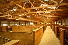 the inside of a barn with wooden stalls