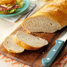 a loaf of bread sitting on top of a wooden cutting board next to a knife