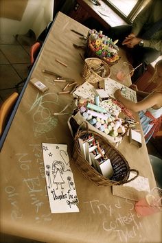 the table is covered with lots of crafting supplies and crafts for kids to make