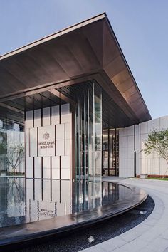 the entrance to an office building with large glass doors and circular fountain in front of it