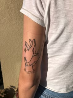 a person with a tattoo on their arm and hand holding something in the other hand