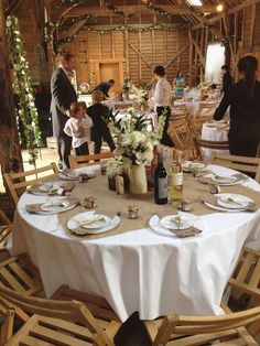 a group of people standing around a table with plates and wine bottles on top of it