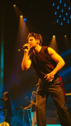 a man standing on top of a stage holding a microphone