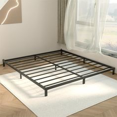 a metal bed frame sitting on top of a wooden floor next to a white rug