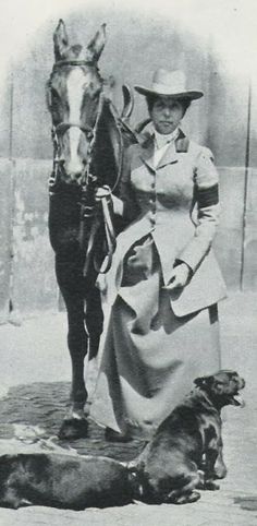 an old black and white photo of a woman with a horse and dog next to her