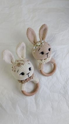 two crocheted stuffed animals sitting on top of a white sheet