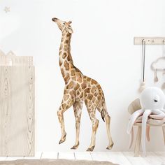 a giraffe standing next to a baby crib in a room with white walls