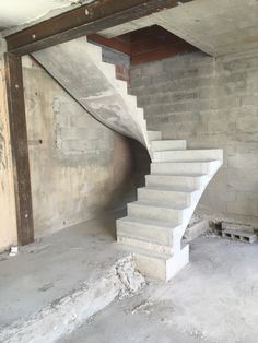 an unfinished room with concrete stairs and cement walls