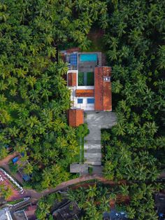 an aerial view of a house in the middle of some palm trees and surrounded by greenery