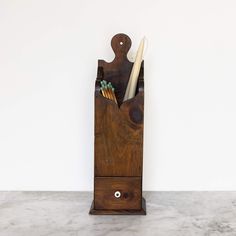 a wooden holder with toothbrushes in it