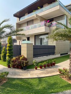 an apartment building with plants and trees in the front yard