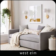 a living room with a gray couch and white rug on top of the floor next to a window