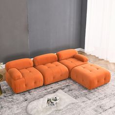 an orange couch sitting on top of a white rug