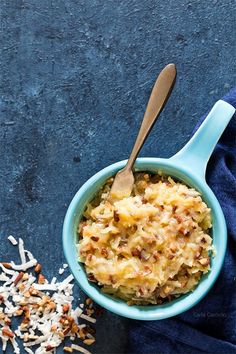 a blue bowl filled with food next to sprinkles and a wooden spoon