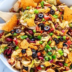 a white bowl filled with nacho salad and tortilla chips