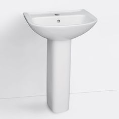 a white pedestal sink sitting next to a wall