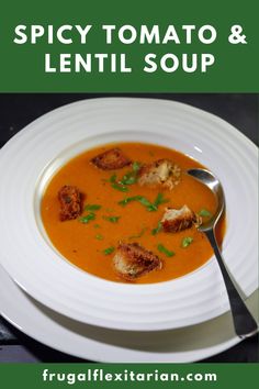 a white plate topped with soup next to a spoon