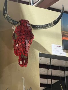 a bull's skull made out of wine bottle caps hanging from the side of a wall